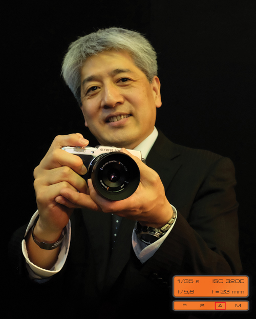 Fujifilm X100s dobrze sobie radzi nawet przy fotografowaniu produktów konkurencji. Na zdjciu Olympusa PEN EP-5 trzyna w rkach Toshiyuki Terada podczas berliskiej konferencji tego producenta.