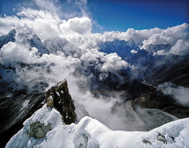 „Fotograficzna odpowied na pytanie – dlaczego si wspinasz?” Wybraem swoje ulubione zdjcie, pochodzce z wyprawy w Himalajach w roku 2002, na pikny szczyt vis-a-vis Mount Everestu – Ama Dablam (6812 m). Na fotografii wida obóz II, namioty rozbite na ostrej turni skalnej w grani – a obok sylwetk Ryszarda Pawowskiego, znakomitego himalaist, ostatniego partnera wspinaczkowego Jerzego Kukuczki. Jestemy w poowie drogi na ten pikny szczyt. Mamiya 7.2; 65 mm f/4; diapozytyw 6x7, Fujichrome Provia 100