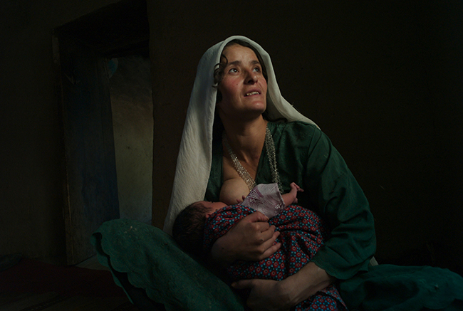 SHAHR-I-BUZORG, AFGHANISTAN- AUGUST 2008 Siamoy breast feeds her month old baby boy Hokim as she goes to visit her sisters at their home in Khourdakon village. Situated in the remote mountainous province of Badakshan, the area has the highest rate of maternal mortality in the world.