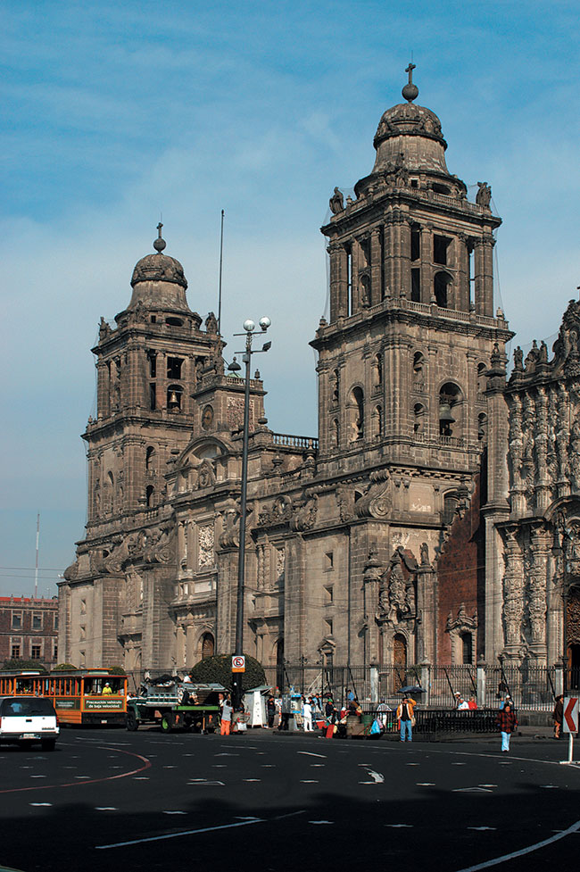 Katedra Metropolitana. Największy kościół Ameryki Łacińskiej, budowany przez 300 lat, jest swoistym leksykonem meksykańskiej sztuki kolonialnej. Na początku był budowany w stylu hiszpańskiego renesansu, ale wykończony został w stylu francuskiego neoklasycyzmu z początku XIX w. Górna część wytwornej fasady i wieże zwieńczone nietypowymi kopułami w kształcie dzwonów zaprojektowali dwaj wielcy architekci neoklasycyzmu: Manuel Tolsa i Jose Damian Ortiz de Castro. Kościół znajduje się w mieście Meksyk. Nikon D100, obiektyw Nikkor ED AF-S 28-70 mm 1:2,8D (ISO 200; t=1/320 s; f=9; ogniskowa 35 mm).