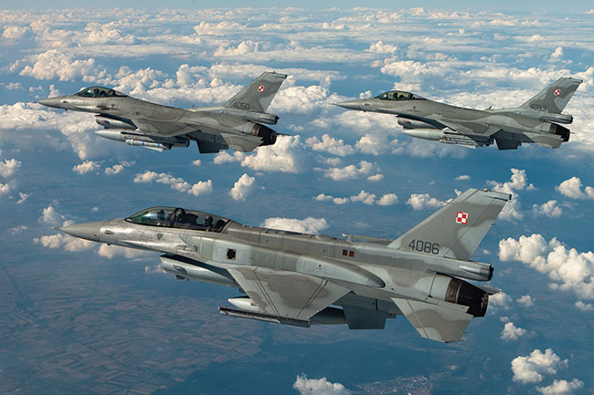 Klucz samolotów F-16, na co dzie stacjonujcych w poznaskich Krzesinach, w locie nad chmurami. Canon EOS-1 D Mark III + Canon EF 24–70 mm f/2,8L USM. 1/640 s; ISO 200; f/10; f=40 mm