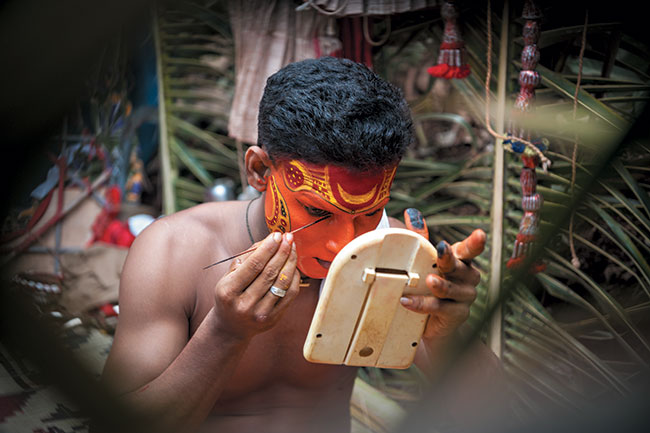 Wykonanie skomplikowanego makijau zajmuje tancerzowi Theyyam czsto nawet kilka godzin. Nikon D3 + Nikkor AF-S 24–70 mm f/2,8 G ED. Par. eksp.: 1/30 s; ISO 640; f/4; f=70 mm