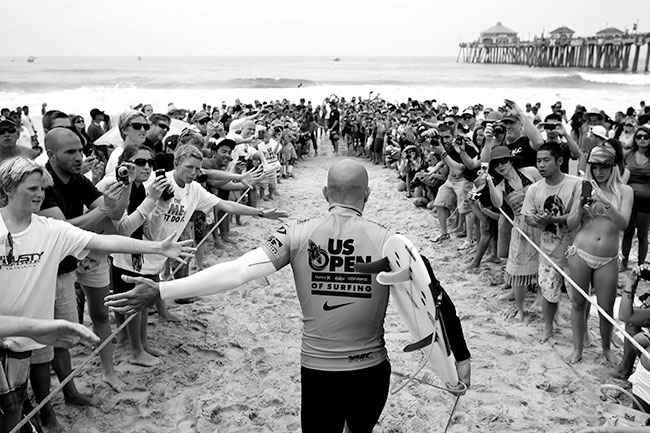 Fotograf:&nbsp;Jimmy Wilson. Sportowiec: Kelly Slater. Miejsce: Huntington Beach, Kalifornia, USA. Wyr&oacute;�nienie w&nbsp;kategorii &bdquo;Lifestyle&rdquo;. Sprz�t: Canon EOS 1D Mark IV z&nbsp;obiektywem EF 24&nbsp;mm f/1,4L II USM. Parametry: ISO&nbsp;100; f/4; 1/1000&nbsp;s. Zawodnik witany przez fan&oacute;w nie zawi&oacute;d� ich nadziei. Jego wyst�p za&nbsp;chwil� przyniesie mu zwyci�stwo w&nbsp;konkursie US Open of Surfing i&nbsp;nagrod� w&nbsp;wysoko�ci 100 tys. dolar&oacute;w. &bdquo;Najwa�niejsze przy powstawaniu tego zdj�cia by�o nawi�zanie przyjacielskich relacji z&nbsp;ochron�&rdquo; &ndash; podkre�la fotograf.