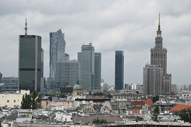 Fotografowanie z dwunastego pitra budynku „Zebra” umoliwia ukazanie centrum Warszawy z nietypowej perspektywy. Z tej wysokoci najwysze budynki stolicy rejestrowane s bez znieksztace, jeli nie liczy tych powstaych na skutek fotografowania przez szyb. Nikon D7500 + 18–105 mm f/3,5–5,6. Par. eksp.: 1/2500 s; ISO 1600; f/13; f=80 mm