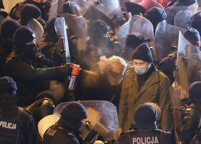 Podczas pokojowej manifestacji kobiet w 102 rocznice uzyskania praw wyborczych posanka Barbara Nowacka pokazuje legitymacj poselsk policjantowi, który atakuje j gazem pieprzowym. 28 listopada 2020 r., Warszawa, (fot. AP Photo/Czarek Sokoowski).