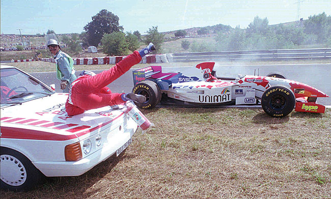 Japoski kierowca Taki Inoue podajcy z ganic w stron samochodu zostaje potrcony przez samochód, który przyjeda mu z pomoc po tym, jak silnik Inoue Footwork Hart zgas podczas wgierskiego Grand Prix F1, 13 sierpnia 1995 r. Nieprzytomny Taki Inoue zosta przewieziony do szpitala. ( fot. AP Photo / Czarek Sokoowski)