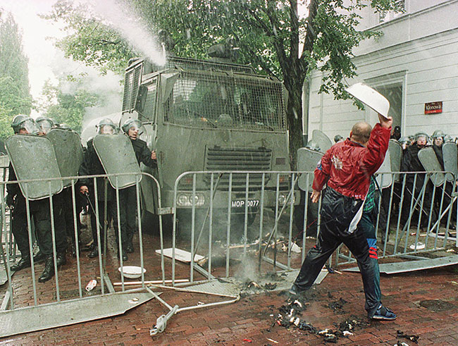 Pracownik przemysu zbrojeniowego, protestujc przed MON, rzuca „pocisk” w policj, która strzela gumowymi kulami, gazem zawicym i armatk wodn w stron demonstrantów w drugi dzie niepokojów robotniczych w Warszawie, czwartek 24 czerwca 1999 r. (fot. AP Photo / Czarek Sokoowski)