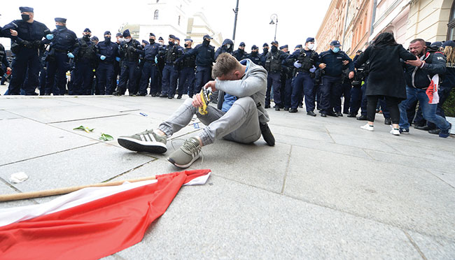 Mczyzna ociera oczy po tym, jak policja uya gazu zawicego przeciwko protestujcym, wciekym na ograniczenia ekonomiczne naoone w zwizku z walk z rozprzestrzenianiem si koronawirusa w Warszawie, 16 maja 2020 r. (fot. AP Photo / Czarek Sokoowski)