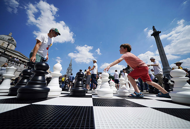 Father and son Graham and Innes McClelland play chess in Trafalgar Square, London as part of ChessFest, organised by Chess in Schools and Communities (CSC), a charity that uses chess to help children's educational and social development. Picture date: Sunday July 18, 2021.  Photograph: Yui Mok