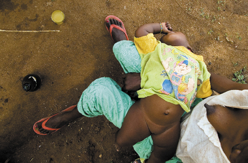 Nieletnia matka upija się winem z miodu podczas karmienia piersią swojego dziecka. Turmi, południowa Etiopia